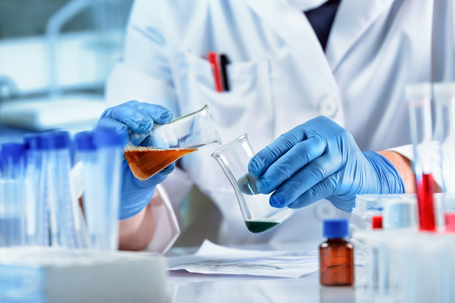 Chemistry lab worker mixing liquids